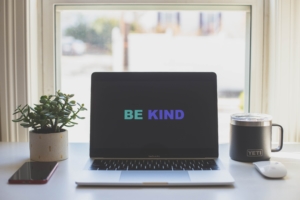This writing desk setup has a message on the computer screen reminding you of writing kindness—"Be Kind" to yourself and your writing life.