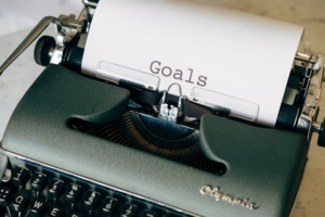 A typewriter helping writers set their writing goals by offering a page already typeset with the word Goals.