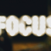 A slightly out of focus image of the word focus spelled in lights, like a writer grasping for focus as they try writing with distractions.